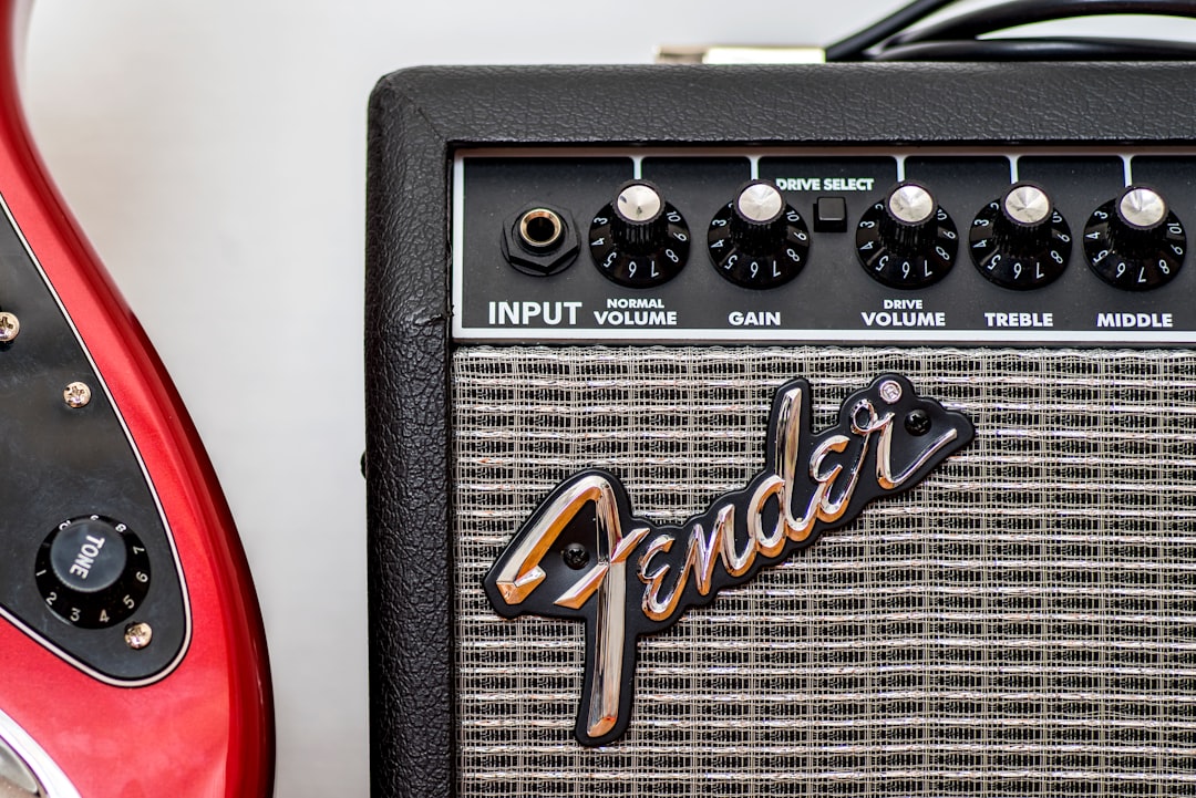 a red guitar and a black amp sitting next to each other